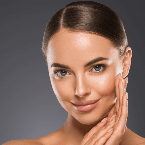 Woman with smooth skin and brown hair touching her face.